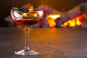 A glass of classic Manhattan cocktail on fireplace background, ideally served at a New Jersey establishment on National Cocktail Day