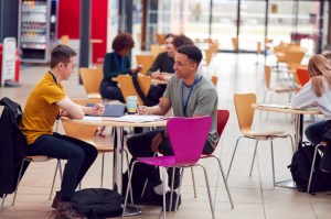 Communal Area Of Busy College Campus With Students At Tables. 4 New England school ranked in the top for college food.