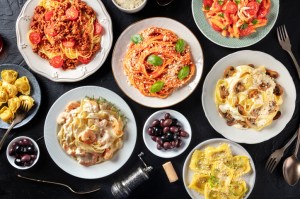 Pasta, many different varieties, shot from the top on a black background, Italian food flat lay. There is a new Boston build-your-own pasta bar.