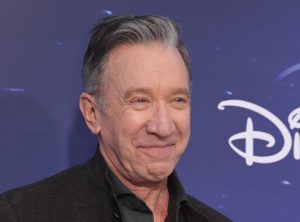Tim Allen attends the Disney+ Original Series "The Santa Clauses" Premiere smiling facing right wearing a black button up, Tim Allen Is 'Geeked' About Returning to TV.