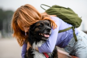 A haggy rescue dog with a young woman hugging.