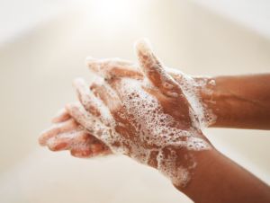 A person washing their hands with soap and water.