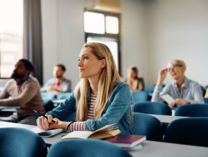 Blonde young woman sitting at college.