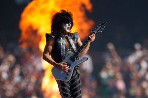 Paul Stanley playing guitar on stage in front of fire
