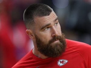Travis Kelce #87 of the Kansas City Chiefs looks on before Super Bowl LVIII facing right with a full beard, Travis Kelce Reveals His Guilty Pleasure Reality Show.