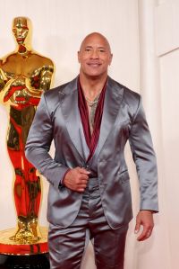 Dwayne Johnson attends the 96th Annual Academy Awards wearing a silver suit.