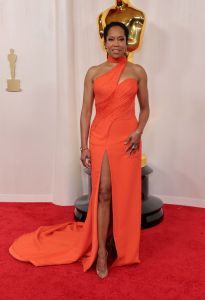 Regina King attends the 96th Annual Academy Awards wearing an orange gown.