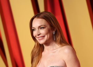 Lindsay Lohan attends the 2024 Vanity Fair Oscar Party smiling facing left wearing a strapless gown, Lindsay Lohan Feels No Rush To 'Snap Back' After Son's Birth.