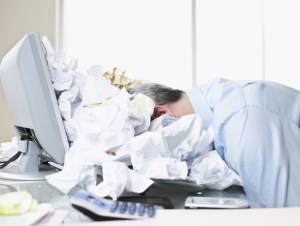 Businessman face down in paper pile, stressed out concept.