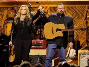 Five Country Music Couples We Adore - Garth and Trisha on stage are wearing black.