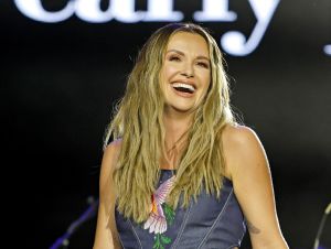 Carly Pearce Was Taken Aback - Carly on stage wearing a blue denim jumpsuit.