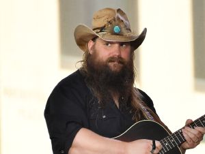 Chris Stapleton Played An April Fool's Joke - Chris on stage in a cowboy hat and black shirt, holding a guitar.