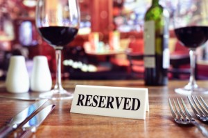Restaurant reserved table sign with places setting and wine glasses ready for a party. New Jersey restaurants most reservations booked via OpenTable.