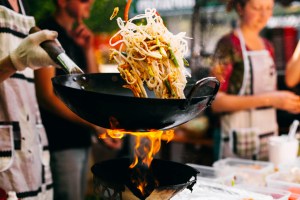 Man cooks noodles on the fire. WokWorks expanding into New Jersey.