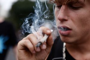A man smoking a joint. Probably listening to these 5 stoner songs for your 420 playlist