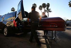 Officers putting a coffin in a car. Could a coffin on wheels be street legal?