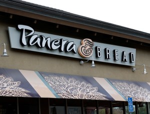 A sign is posted on the exterior of a Panera Bread