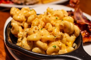Macaroni and cheese also called mac n cheese served in black small pan. Mac and Cheese franchise will expand in Florida.