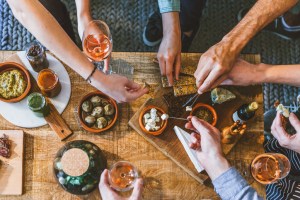 top view of a group of people around a table enjoying food and friendship. Top-rated tapas restaurant in New Jersey is also a rum bar.