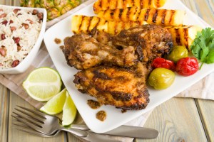 Jerk Chicken served with pineapple, chills and rice and peas at the best Caribbean restaurants