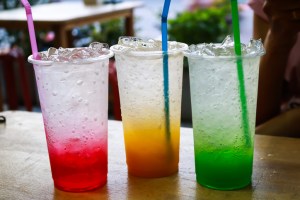 Three colorful sodas with straws on a table. 2 new fast-food restaurant chains.
