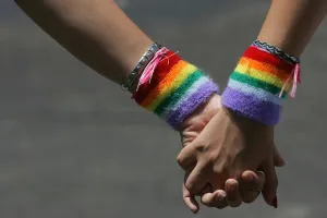 Lesbians holding hands with Rainbow Pride sweatbands. Are lesbians more likely to experience orgasms?