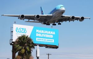 Marijuana delivery ad under a plane. How many pounds of weed was a woman busted with in her luggage?