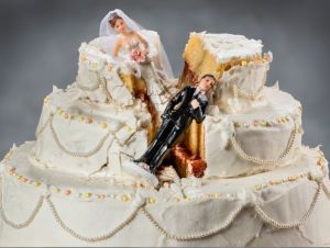 Bride and groom figurines collapsed at ruined wedding cake - divorce trends concept