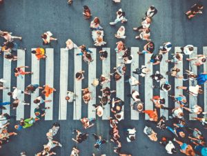 Aerial. People crowd on pedestrian crosswalk. Top view background. Toned image. Human trafficking concept.