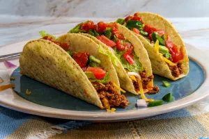 Beef tacos with romaine lettuce cheddar cheese red onions and salsa. A Boston restaurant is holding Taco Bell Night on Tuesdays.