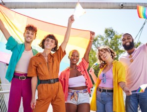 Friends, city and happy lgbt people with rainbow flag for support, queer celebration and parade for solidarity. Diversity, lgbtq community and group enjoy freedom, happiness and pride identity