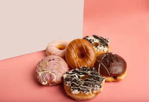 a selection of various doughnuts in front of a white box in a pink background. Salty Donut has 3 Atlanta locations.