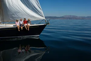 Four people sat on a sailboat in a lake. Best boating vacations on the east.