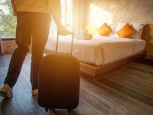 Cropped shot of tourist woman pulling her luggage to her hotel bedroom after check-in., vacation concept