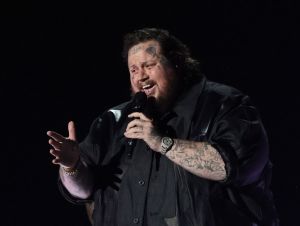 Jelly Roll performing on stage in black at the ACM awards in 2023.