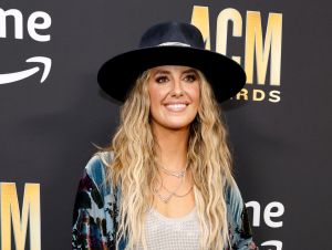 Lainey Wilson at the ACM red carpet wearing a blue outfit and hat.