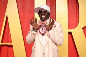 Flavor Flav posing for a picture with his big clock chain. How is Flavor Flav helping Red Lobster?