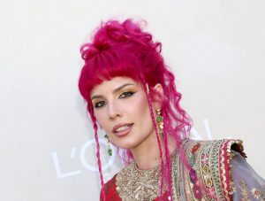 Halsey attends Gold Gala 2024 at The Music Center smiling wearing a long hot pink half up hairstyle and traditional Indian clothing. Halsey’s Lupus Diagnosis Garners Fatphobic Comments.