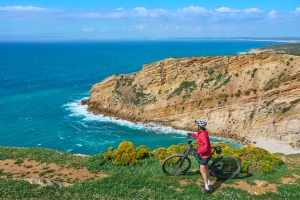 A woman cycling with her electric mountain bike on the cliffs. New England bike tour