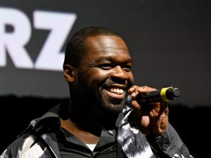 Curtis "50 Cent" Jackson speaks onstage during the “Power Book II: Ghost” Season 4 New York City Premiere smiling facing right holding a microphone, 50 Cent Attended A Diddy Roast In Hopes Of Seeing Diddy.
