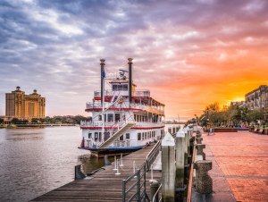 Georgia at sunset with a large boat. People are moving to two Georgia cities in hopes for a new life.