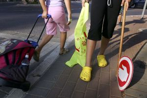 A crossing guard wearing crocs helping a student cross the road. A little crossing guard is in big trouble in Delaware County!