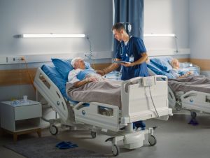 Man in a hospital bed with a male nurse.