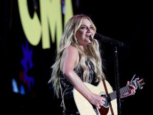 Kelsea Ballerini wearing black and performing on the CMA Fest stage in Nashville. .